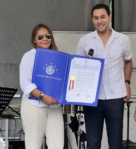 Jasmine holds up a proclamation from the NYC Council in her honor.