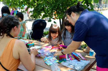 Man outside with children using art supplies