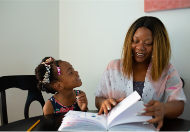 Woman showing book to child