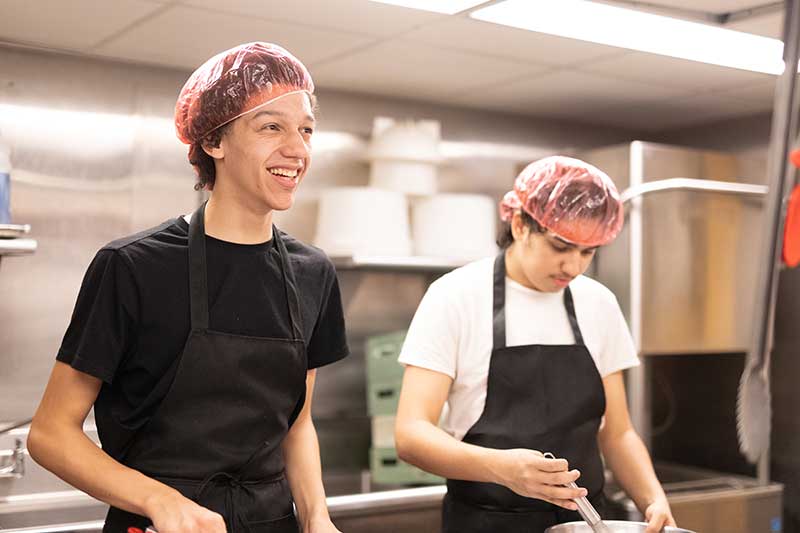 Two people working at a restaurant kitchen
