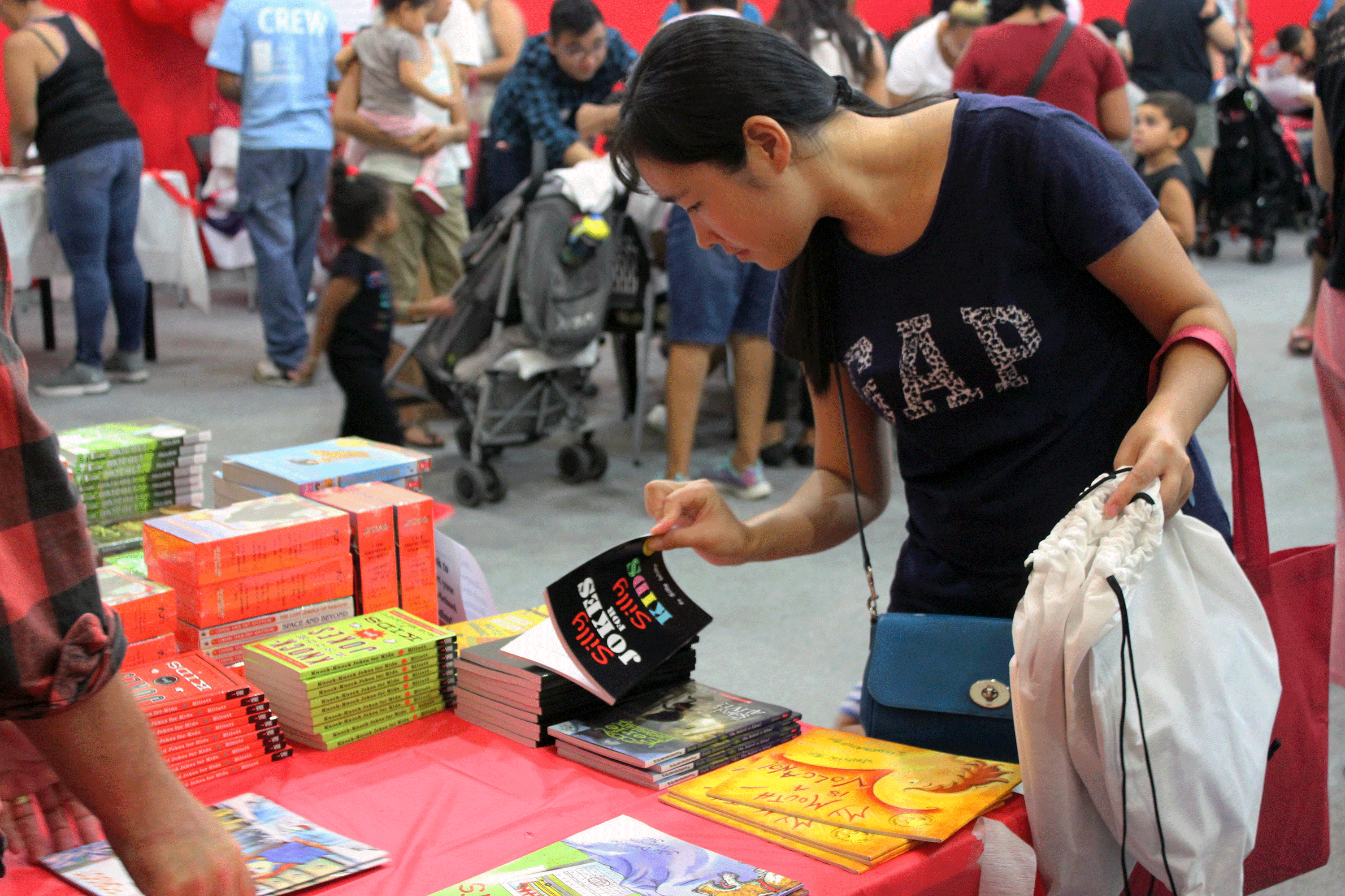 Women looks at books at back to school event, fall 2017