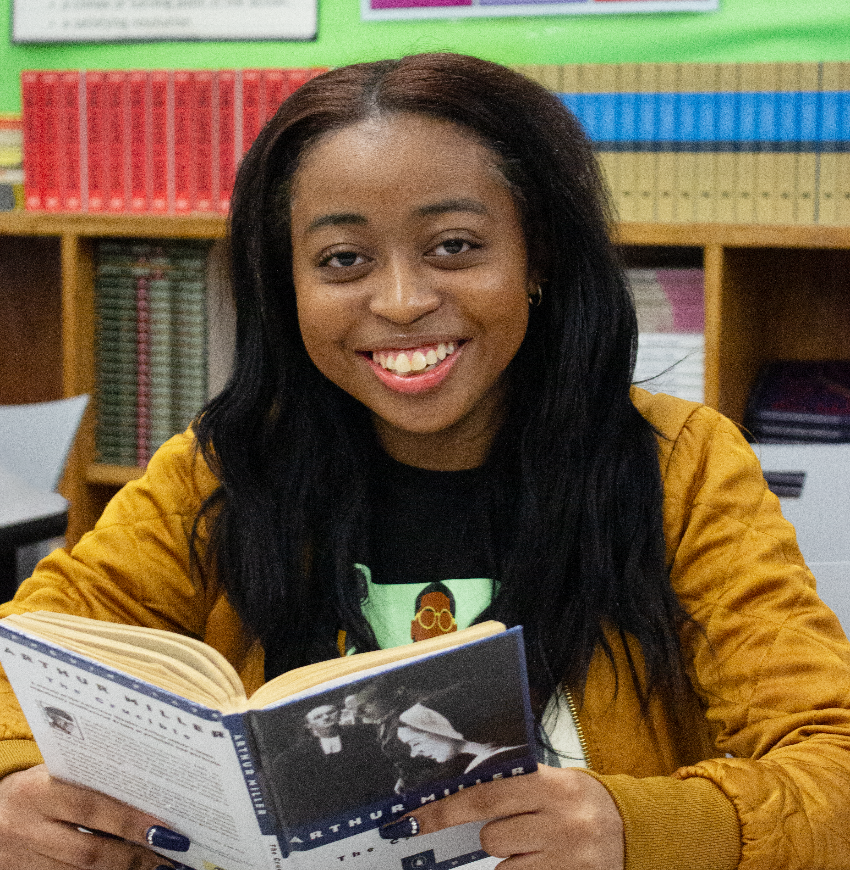 Nicole Satchell smiles while reading a book.