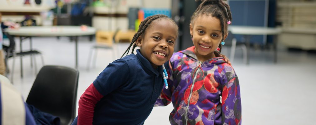 Two girls hug each other and smile in the BGR game room.