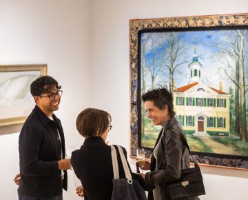 A group of art viewer chatting and standing in front of a landscape painting