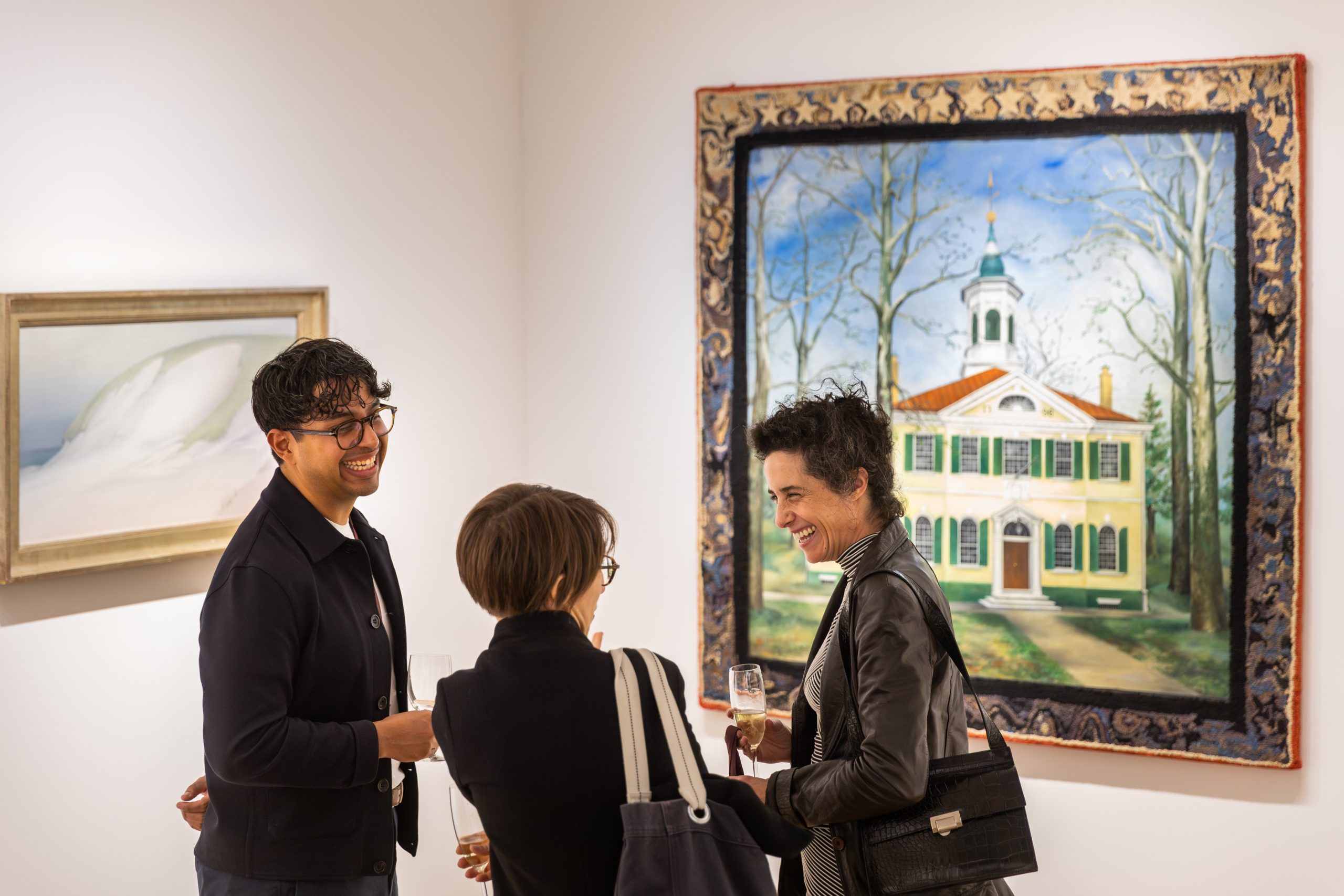 A group of art viewer chatting and standing in front of a landscape painting