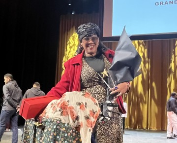 Rosemarie holds her first place award on stage at the United Palace Theater.