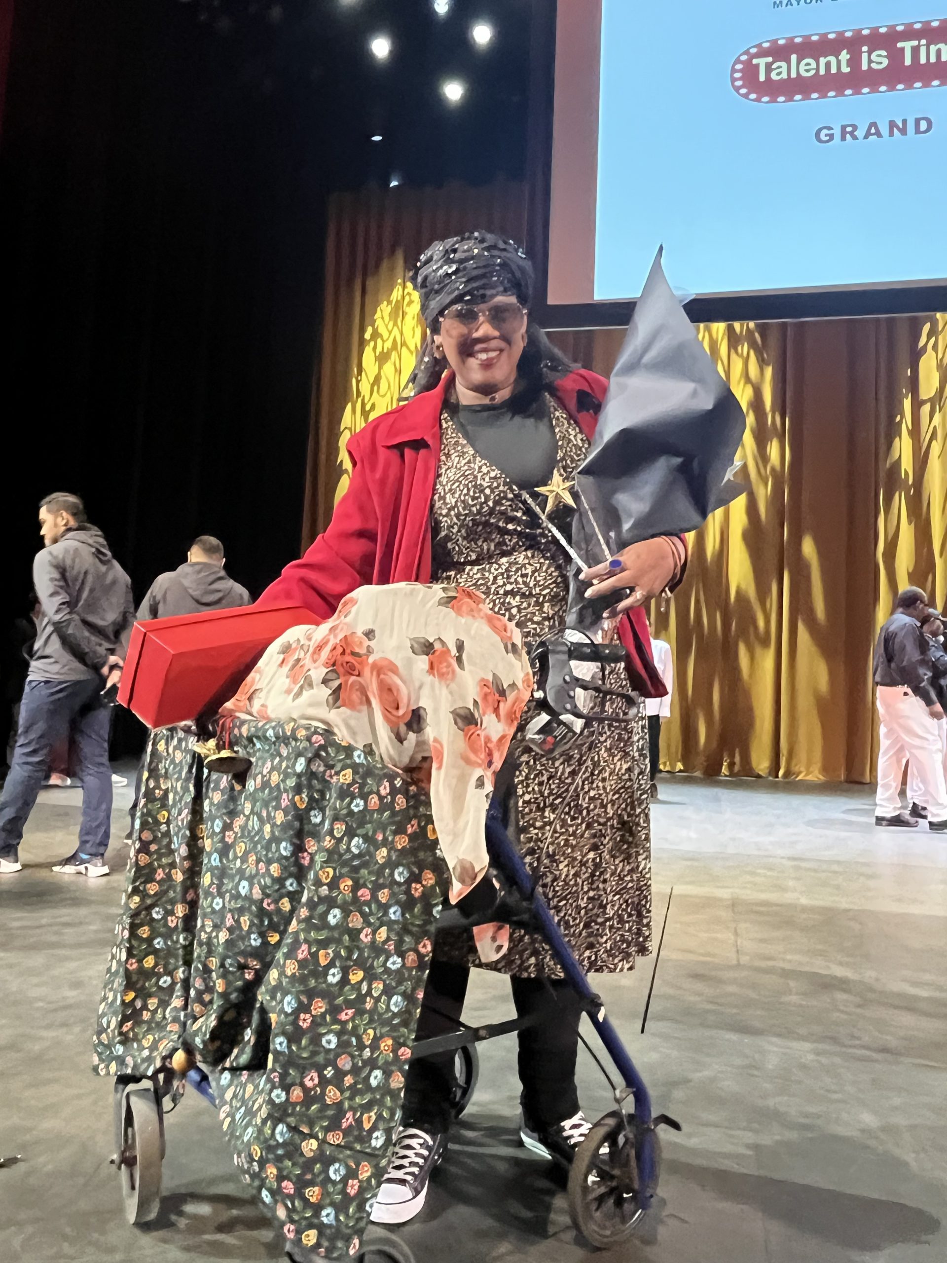 Rosemarie holds her first place award on stage at the United Palace Theater.